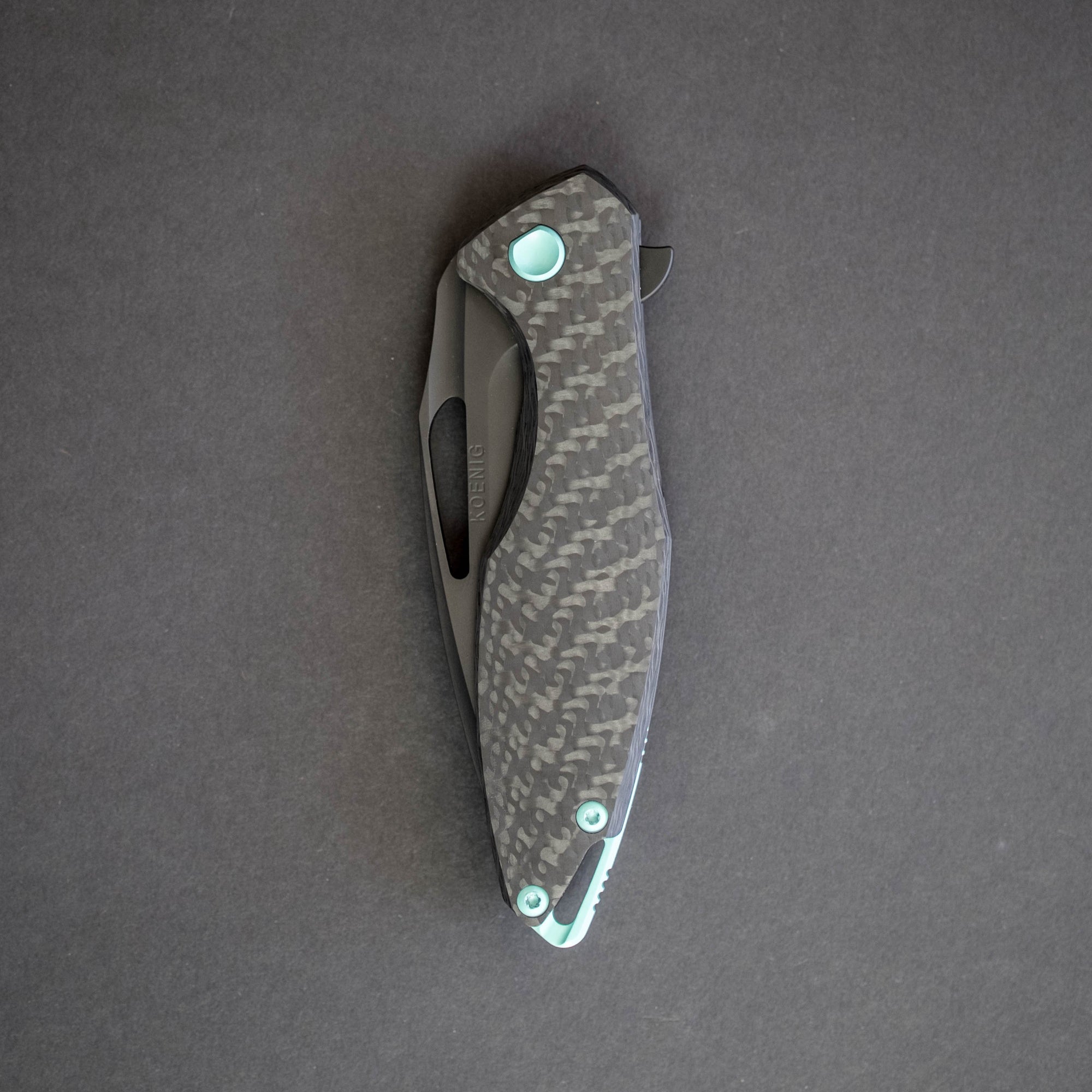 https://urbanedcsupply.com/cdn/shop/products/knife-koenig-arius-contoured-carbon-fiber-dlc-back-w-tiffany-blue-3_2000x.jpg?v=1531520432